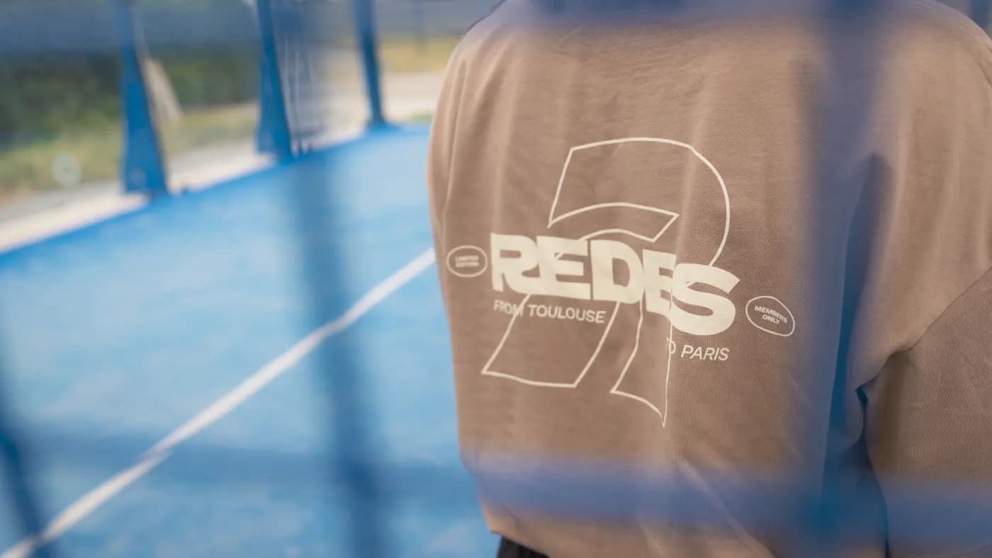 Membre REDES de dos sur un court de padel