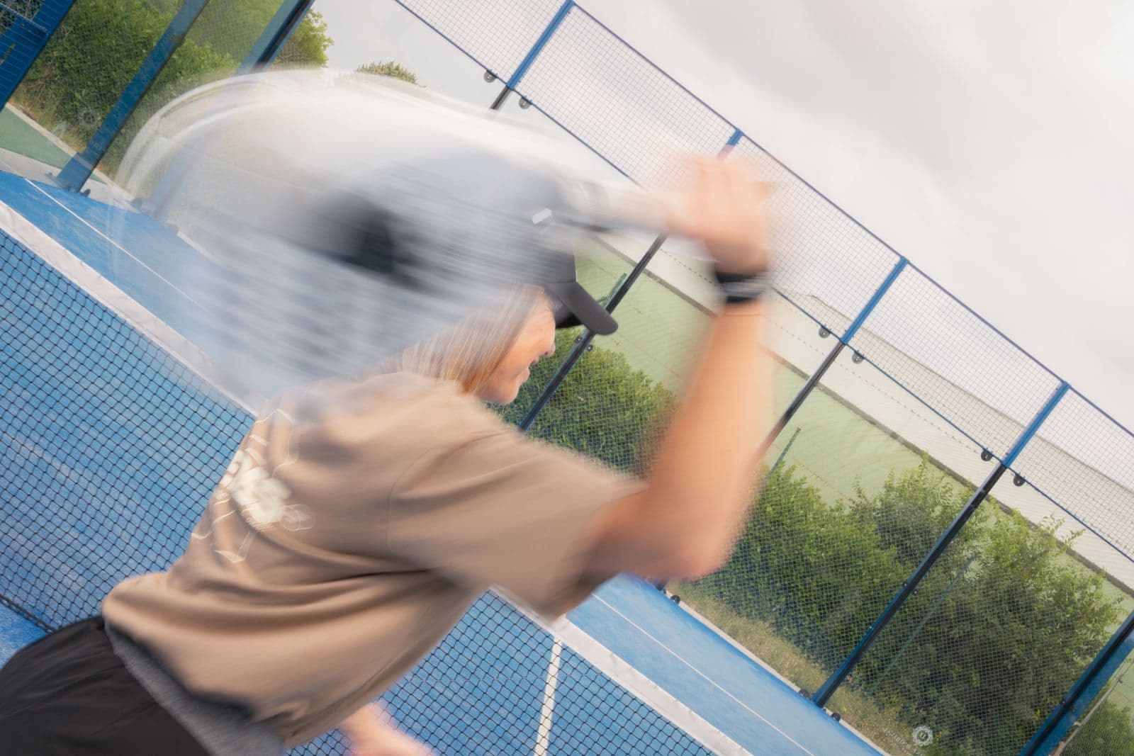 Joueuse REDES en pleine frappe sur un court de padel